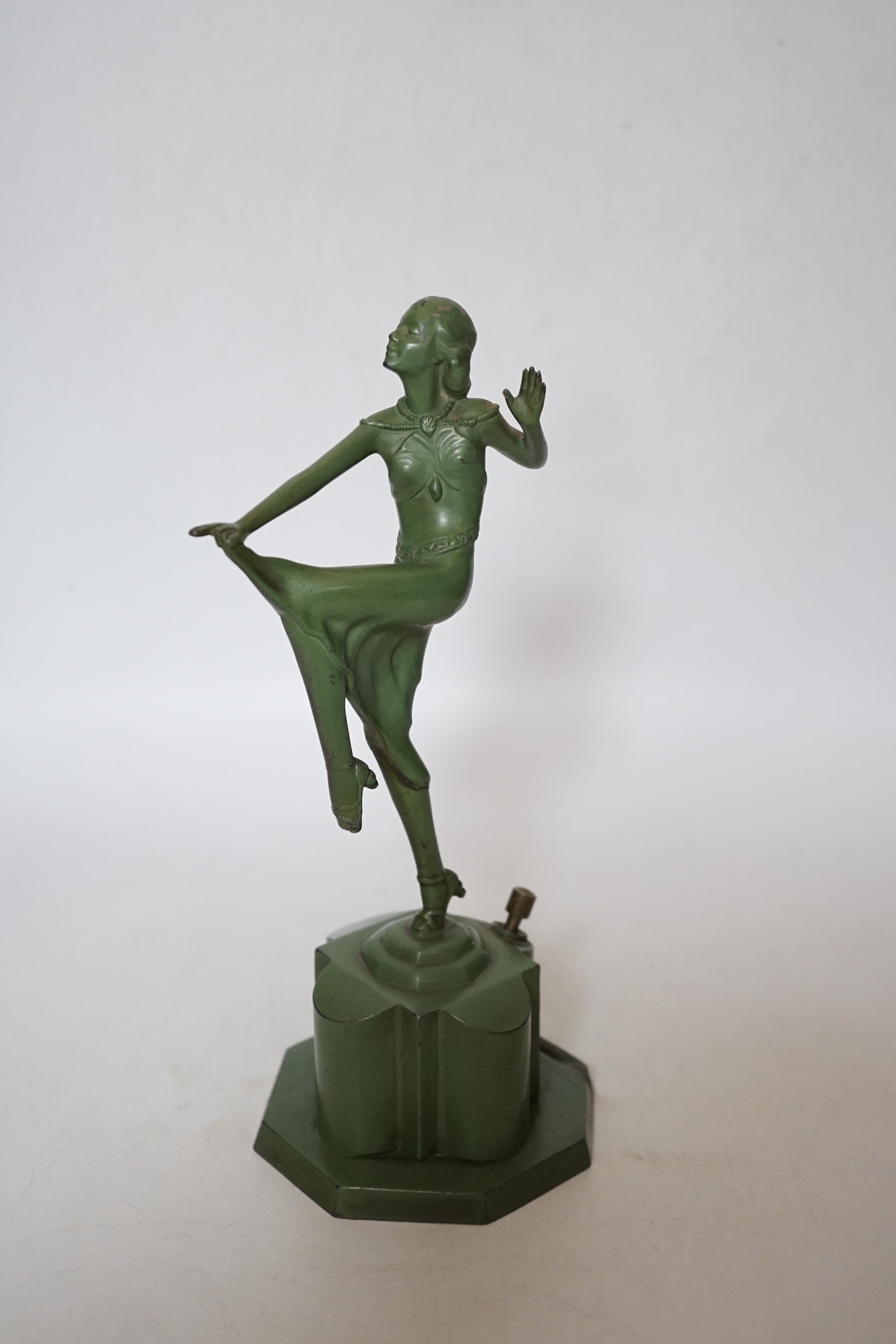 An Art Deco match striker in the form of a dancing woman, with patinated green finish, 25cm